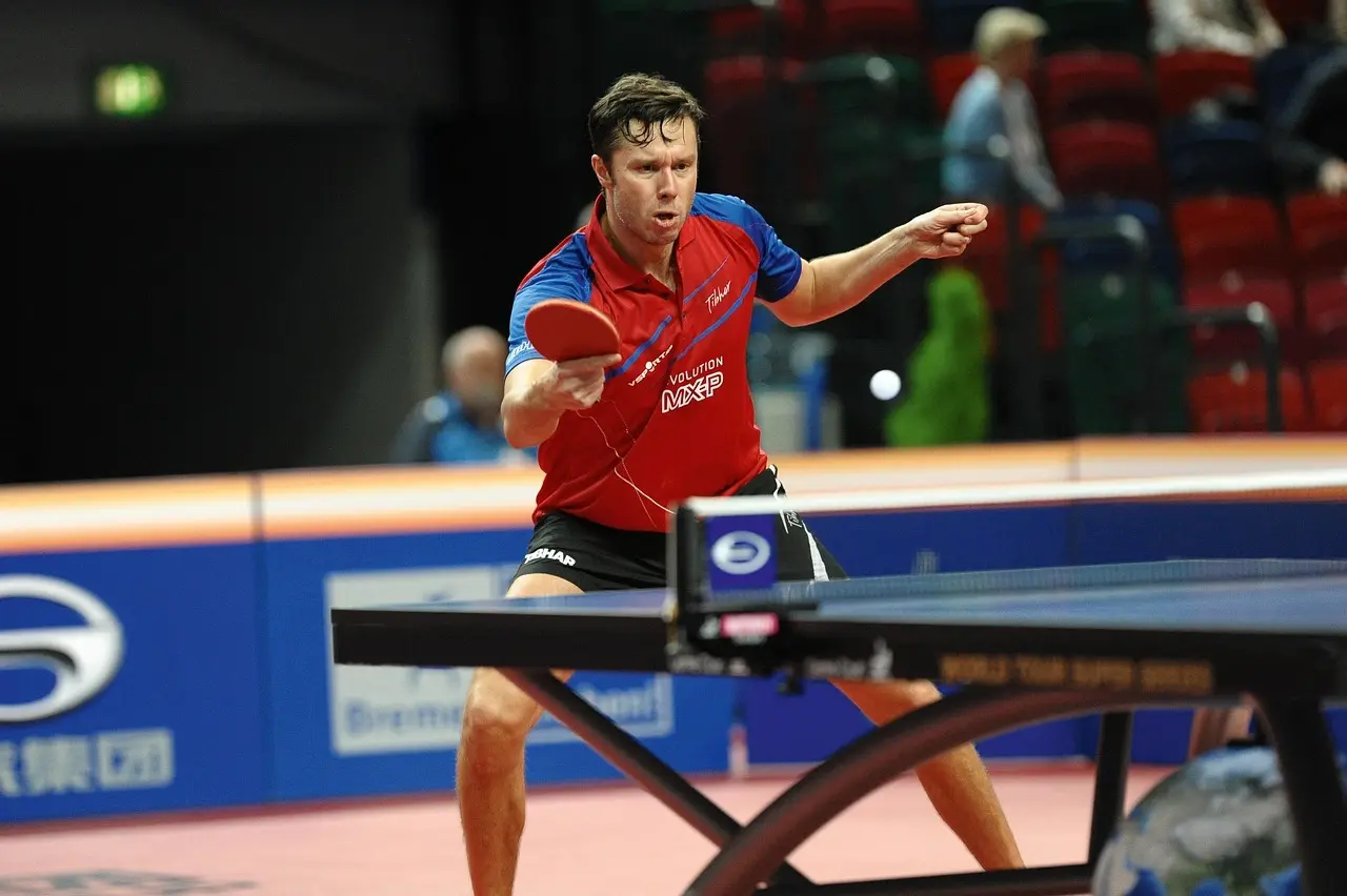 Bordtennisspiller slår bolden ved bordet